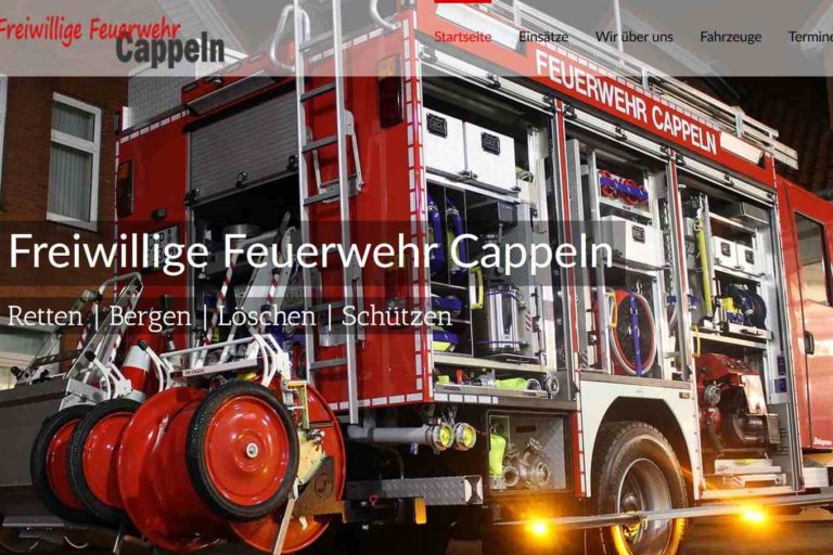 Feuerwehrfahrzeug der Freiwilligen Feuerwehr Cappeln mit geöffneten Fächern, Ausrüstung gut sichtbar, Schriftzug „Feuerwehr Cappeln“ auf dem Fahrzeug, Innenbereich einer Halle.