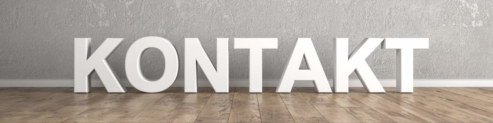 Große weiße Buchstaben "KONTAKT" stehen auf einem Holzfußboden vor einer grauen Wand.