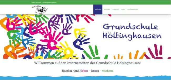 Bunte Handabdrücke und der Text "Grundschule Höltinghausen" auf einer Webseite, darunter ein Willkommensgruß.
