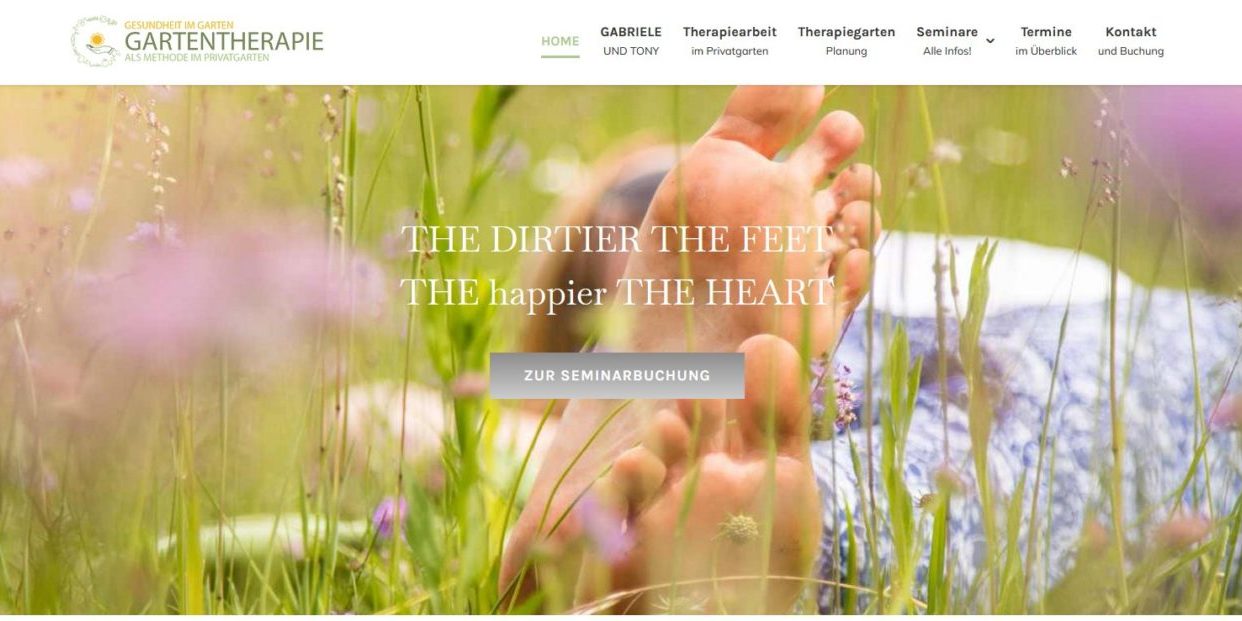 Nahaufnahme von nackten Füßen im Gras, mit dem Text „Je schmutziger die Füße, desto glücklicher das Herz“